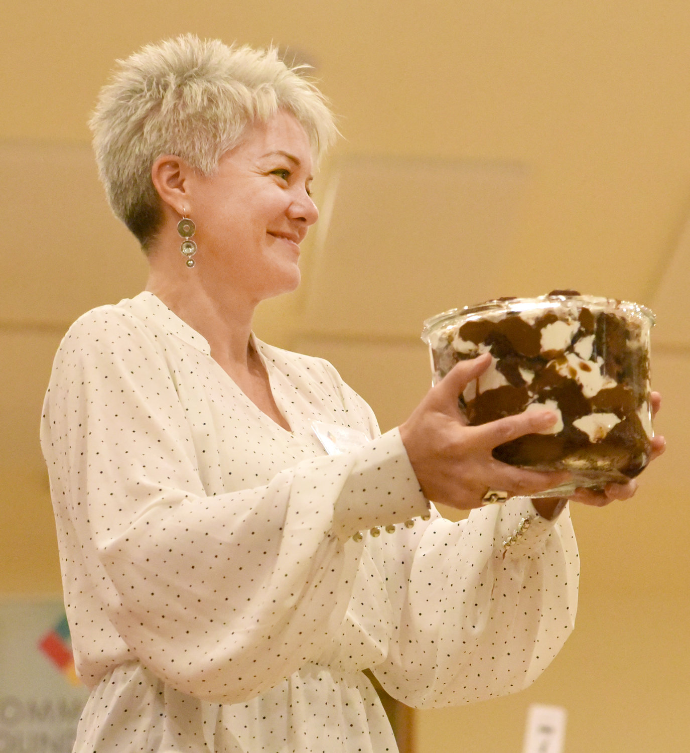 Heather Marek shows off a Chocolate Trifle Cake, donated by Mary Jane Schlabaugh-Gaffey, at the Washington County Community Foundation’s Chef Spotlight dinner on Nov. 4. Auctioneer Dwight Duwa gathered some laughs as he bid on the dessert while auctioning it off. Proceeds from the dessert auction benefitted both the foundation and the Kalona Historical Village.